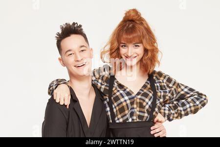 Zwei lächelnde Leute posieren in stilvollen Outfits. Stockfoto