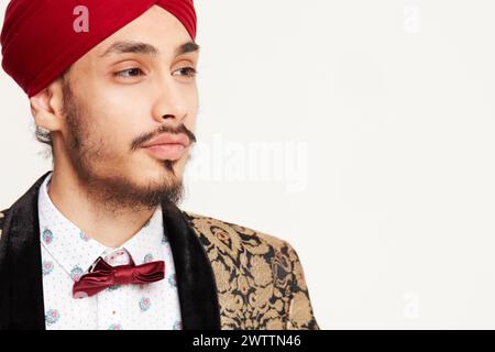 Mann in Turban und Fliege, der zur Seite schaut Stockfoto