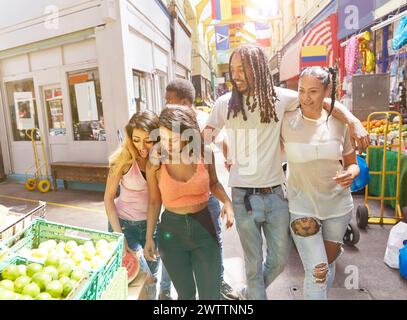 Freunde, die einen sonnigen Tag auf einer Marktstraße genießen Stockfoto