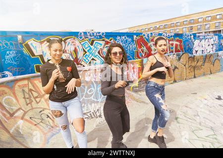 Drei Frauen posieren vor einer Graffiti-Wand Stockfoto