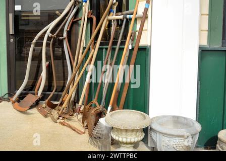 Alte Farm Crop Tools auf dem Gehweg vor dem Antiquitätenladen. Stockfoto