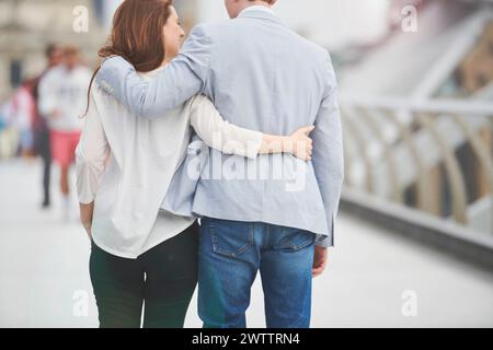 Ein Paar, das Arm in Arm auf einer Brücke läuft Stockfoto
