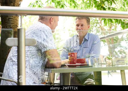 Zwei Männer unterhalten sich an einem Café-Tisch. Stockfoto
