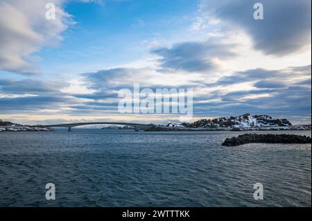 Wellen in einem Fjord unter einem wunderschönen polaren Wolkenhimmel in der Nähe der Brücke zur Insel Hennngsvaer, Lofoten, Norwegen. Stockfoto