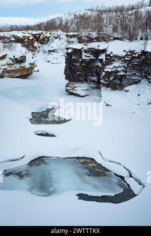 Malerischer Blick auf Schnee, Eis, Wasser und steile Felswände der Abisko River Gorge im Abisko National Park, Nordschweden. Stockfoto