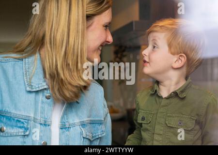 Ein herzerwärmender Moment, als ein kleiner Junge seine Mutter mit Liebe und Neugier ansieht. Stockfoto