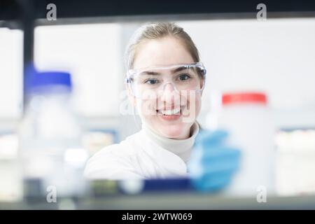 Junger Wissenschaftler lächelt im Labor Stockfoto