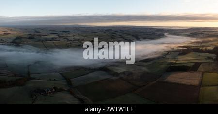 Aus der Vogelperspektive auf niedrig liegende Nebel- oder Wolkenumkehr entlang des River Tyne Valley an der Haydon Bridge nahe Hexham an einem kalten Wintermorgen Stockfoto