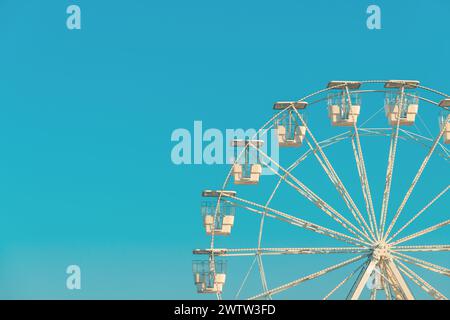 Das riesige weiße Riesenrad für Panoramablick im Vergnügungspark ist beliebte unterhaltsame Fahrt, die am hellen sonnigen Tag am blauen Himmel gedreht wird, Cop Stockfoto