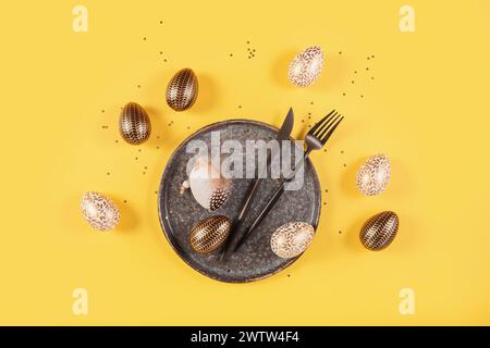 Tischplatz und festliches osterdekor auf gelbem Hintergrund Stockfoto