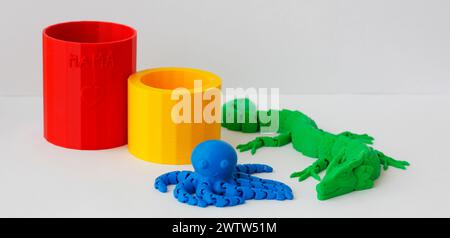 Sammlung von vier bunten Kunststoffprodukten, die von einem Kind mit einem 3D-Drucker erstellt wurden. Verschiedene Kunststoffprodukte, die durch 3D-Druck hergestellt werden Stockfoto