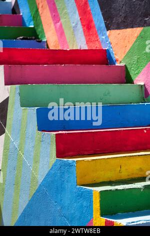 Die Aussicht auf eine Treppe mit Stufen in kräftigen Farben und geometrischen Mustern, die eine verspielte Dimension verleihen Stockfoto