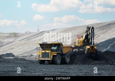 Großer Muldenkipper und Bagger. Schwere Maschinen, die Kohle in Steinbruch laden Stockfoto