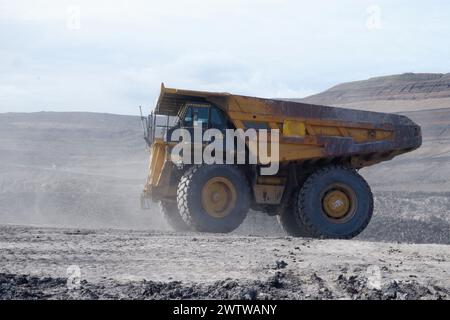 Ein alter rostiger gelber Bergbauwagen auf Arbeit, der Kohle transportiert Stockfoto