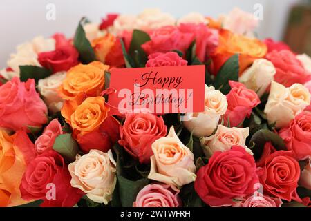 Blumenstrauß mit schönen Rosen mit Happy Birthday Karte, Nahaufnahme Stockfoto