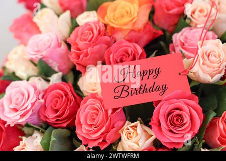 Blumenstrauß mit schönen Rosen mit Happy Birthday Karte, Nahaufnahme Stockfoto
