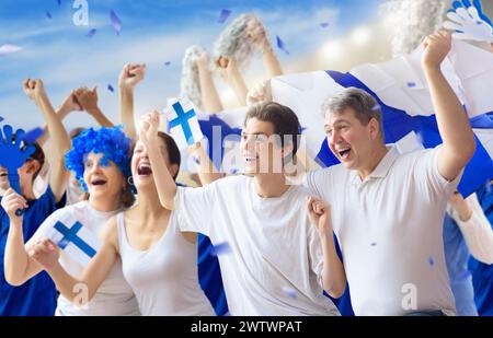 Finnischer Fußballfan im Stadion. Finnische Fans auf dem Fußballfeld beobachten das Spiel der Mannschaft. Gruppe von Fans mit Flagge und Nationaltrikot Stockfoto