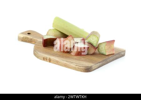 Verschiedene Rhabarberstiele in verschiedenen Farben von blassgrün bis tiefrot auf Holzspanplatten isoliert auf weißem Hintergrund Stockfoto