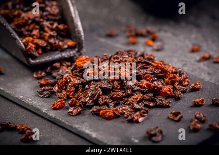 Bio getrocknete berberis und Schaufel auf schwarzem schwarzem Grund Stockfoto