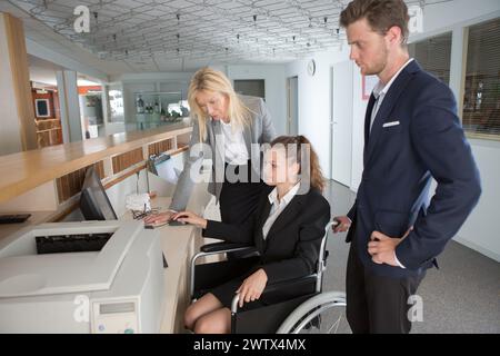 Geschäftsfrau im Rollstuhl als Rezeptionistin Stockfoto