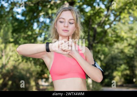 Porträt eines jungen Fitness-Mädchens, das ihre Herzfrequenz überprüft Stockfoto