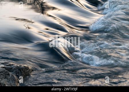 Schnelles Wasser fließt im Fluss über steinigen Boden und bildet Kaskaden - abstrakte Landschaft aus nächster Nähe Stockfoto