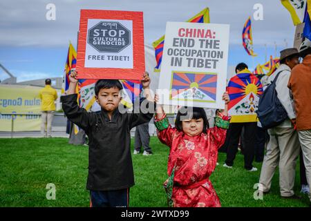 Zwei Kinder halten: "Stoppt den kulturellen Völkermord, befreit Tibet!" Und Plakate "China: Ende der Besatzung in Tibet" während der Demonstration. Tibeter, Uiguren, Hong Kongers und chinesische Demonstranten versammelten sich zu einer Demonstration auf dem Rasen vor dem Parlamentsgebäude in Canberra während des Besuchs des chinesischen Außenministers Wang Yi in Australien am 20. März. Die Demonstranten beschuldigten die chinesische Regierung, Gräueltaten gegen Menschen in Tibet, Hongkong, Ostturkistan und Festlandchina begangen zu haben. Sie verlangten, dass die australische Regierung die Menschenrechte in ihren Beziehungen zu China Vorrang vor dem Handel einräumt. Stockfoto