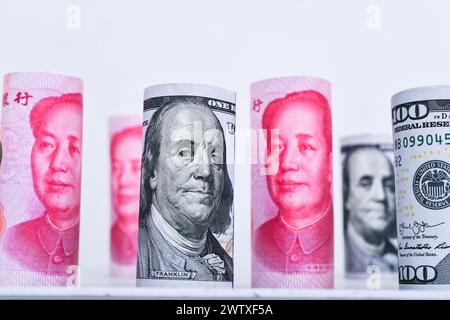 Rollen 100 US-Dollar und 100 chinesische Yuan Renminbi Banknoten Hintergrund. Stockfoto