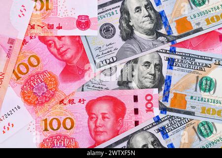 100 US-Dollar und 100 chinesische Yuan Renminbi-Banknoten Hintergrund. Stockfoto