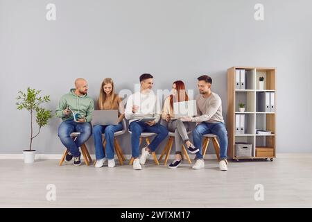 Gruppe junger Männer und Frauen, die auf ein Vorstellungsgespräch, eine Arbeitssitzung oder eine Prüfung warten Stockfoto