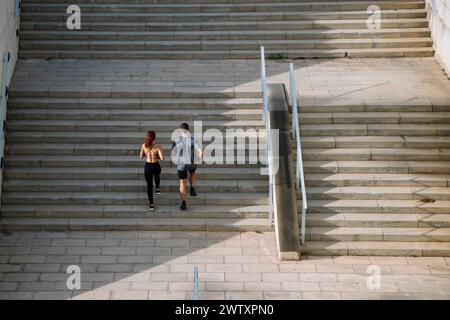 Sportliches Paar während des Trainings, die Treppe läuft draußen. Fitness aktiver Lebensstil sportliche Menschen, die Herz-Kreislauf-Training beim Treppensteigen machen. Stockfoto