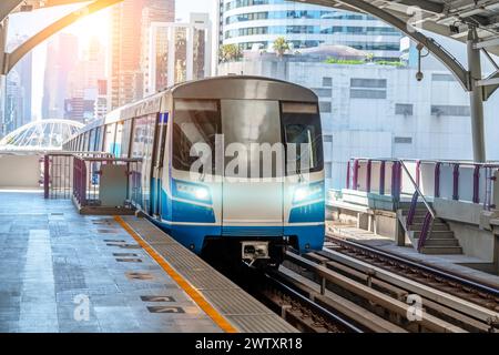 Elektrozug helle leichte Eisenbahnwagen rastet an Bahnhof fährt entlang der Strecke Eisenbahnstraße Viadukt durch die moderne Stadt der Gebäude, Skysc Stockfoto