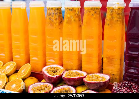 Frisch gepresste Passionsfrucht und Granatapfelsaft in Flaschen zum Verkauf an der Theke Stockfoto