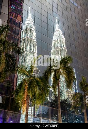 Beleuchtet in einem silbrigen Licht gegen den Abendhimmel, reflektiert von spiegelähnlichen Glasfenstern eines nahe gelegenen Firmenhochhauses. Stockfoto