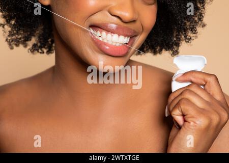 Schwarze Frau, die Zähne mit hellem Lächeln flossiert, Nahaufnahme Stockfoto