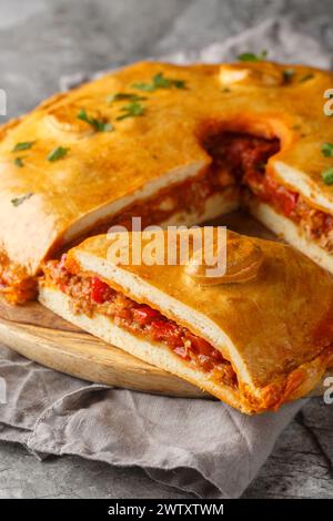 Spanische Empanada Gallega Galicische Pork and Pepper Pie Nahaufnahme auf dem Brett auf dem Tisch. Vertikal Stockfoto