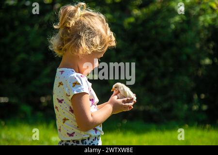 Ein Kind spielt mit einem Huhn. Selektiver Fokus. Stockfoto