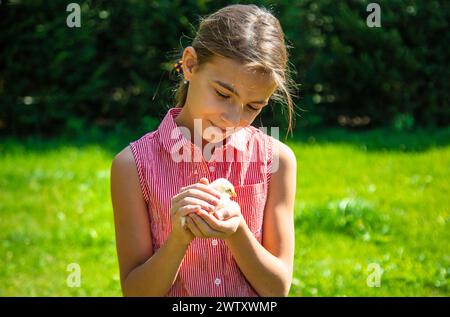 Ein Kind spielt mit einem Huhn. Selektiver Fokus. Tier. Stockfoto