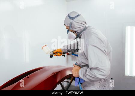 Authentische Aufnahme. Automaler Reparaturmaler Maler in der Kammermalerei AutoStoßfänger im Autodienst. Stockfoto