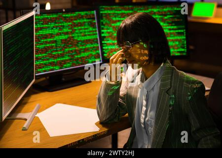 Müde weibliche Programmiererin nachts im Büro Stockfoto