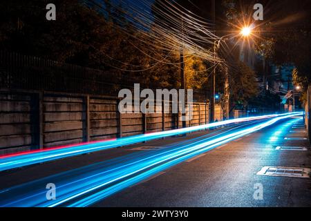 Lange, verschwommene Spur von einem Fahrzeug bei Nacht auf der Straße Stockfoto