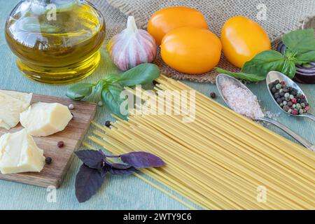 Rezept für Nudeln mit Tomaten oder Makkaroni al Pomodoro Nahaufnahme von Spaghetti, gelben Tomaten, Olivenöl, Basilikum, Parmesan, Zwiebeln, Knoblauch und Gewürze. Stockfoto