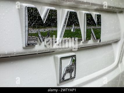 RIBCEV LAZ, SLOWENIEN - 20. APRIL 2014: Logo der Firma MAN mit Löwenabzeichen auf weißem Bus nach Frühlingsregen Stockfoto