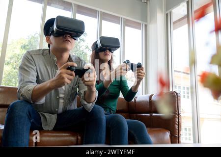 Das junge Paar hat eine tolle Zeit beim Spielen von VR-Spielen zu Hause Stockfoto