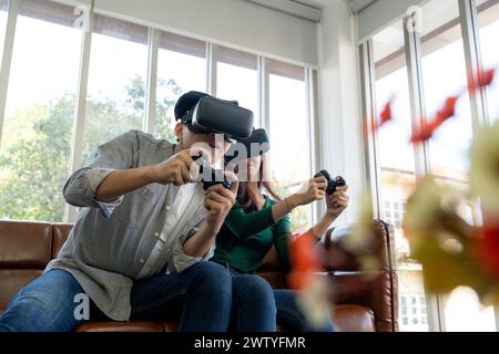 Das junge Paar hat eine tolle Zeit beim Spielen von VR-Spielen zu Hause Stockfoto