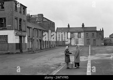 Frauen im Chat in einer Straße mit Brettern vernagelt Häuser Abriss, in Erwartung Butetown (Tiger Bay), Cardiff, Wales, 1974 Stockfoto