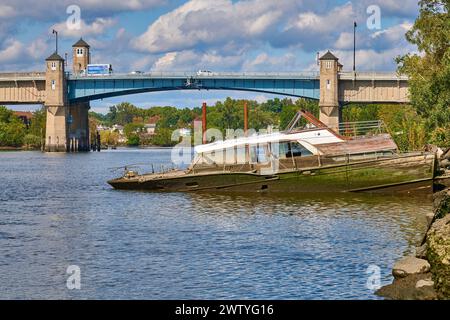 Halb versunkenes Vintage-Boot. Am Hackensack River in New Jersey, USA. Blick Richtung Norden auf die Zugbrücke auf der Winant Avenue, Route 46 East Stockfoto