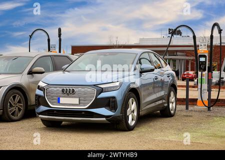 Eisblau Audi Q4 Sportback 40 e-tron vollelektrische Autoladebatterie an der Ladestation. Salo, Finnland. März 2024. Stockfoto