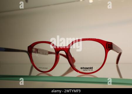 Rote Gläser auf einem Glasregal in einem elektrischen blauen Rechteckmuster Stockfoto