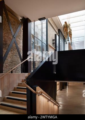 Treppe zum Foyer mit hängender Pferdeskulptur. Brighton Dome Corn Exchange and Studio Theatre, Brighton, Großbritannien. Architekt: Feilden Clegg B. Stockfoto